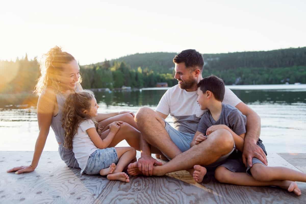 family sitting by lake