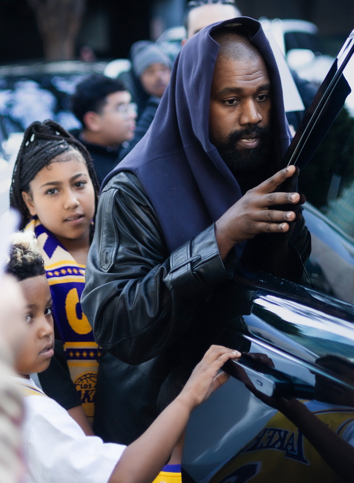 kanye west getting into a car with north west and saint west